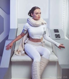 a woman sitting on top of a white chair in front of a machine with her arms crossed