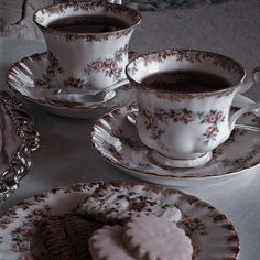 two cups and saucers with cookies on them