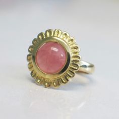 A stunning pinkish orange salmon colored coral cabochon gemstone is the focal point for this statement ring. The color is bright, vibrant, and perfect for summer. Adding to the sunny feel of the ring is the setting. The coral is featured as the center of a beautiful gold flower, with etched gold creating the petals that sit delicately on your hand. Metal: Tests as 14K Yellow Gold Coral: 9 MM Cabochon Size: 5.25 For a greater selection of jewelry please visit our website at www.BlackMarketLLC.com Beach Rings, Pinkish Orange, Orange Salmon, Alternative Engagement Rings, Salmon Color, Pink Coral, Gold Flower, Gold Floral, Floral Flower