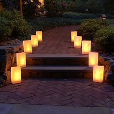 lighted candles sitting on steps in the middle of a garden