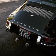 an old porsche sits parked on the street