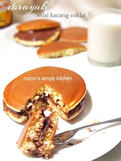 a white plate topped with pancakes next to a glass of milk