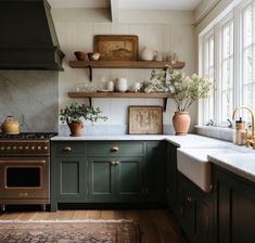 a kitchen filled with lots of green cabinets and counter top space next to a window