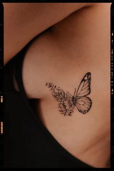 a woman's stomach with a butterfly tattoo on her chest and flowers in the bottom