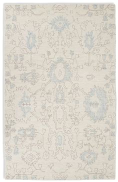 a white rug with blue and grey designs on the bottom, in front of a white background