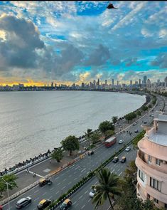 an aerial view of a city and the ocean with cars parked on the street in front of it