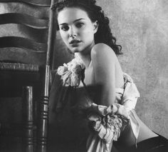 a black and white photo of a woman sitting on a chair