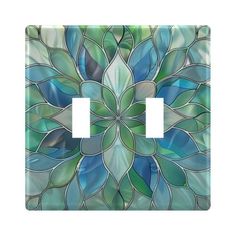 a decorative light switch plate cover with blue and green leaves in the center, on a white background