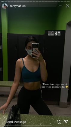 a woman taking a selfie in the mirror with her cell phone and wearing a sports bra top