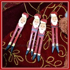 three wooden santa claus ornaments hanging from a red velvet bag