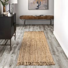 a living room with wood flooring and a painting hanging on the wall above it