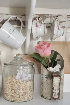 some jars and containers with flowers in them