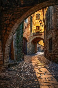 an alley way with stone buildings and cobblestones