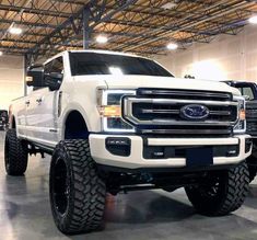 a white truck parked in a garage next to other trucks