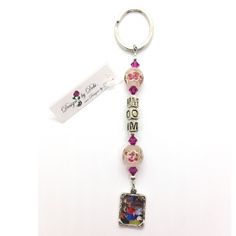 a key chain with beads and charms hanging from it's side on a white surface