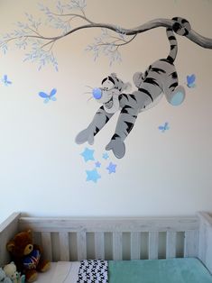 a baby's room with a tiger wall decal and crib bedding