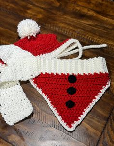 a crocheted hat and scarf on a wooden floor with a pair of scissors