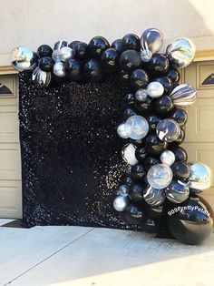 black and silver balloons in front of a garage door