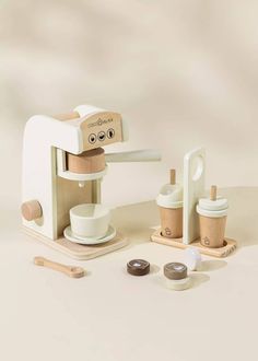 a toy coffee maker with cups and spoons