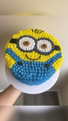 a cake that looks like a minion is being held by someone's hand