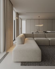 a living room with a large sectional couch in front of a window and a rug on the floor