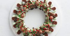 a white plate topped with a christmas wreath made out of cookies and candy canes