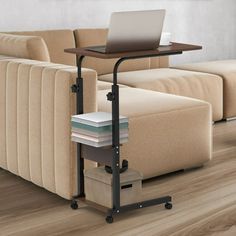 a laptop computer sitting on top of a wooden table next to a beige sectional couch