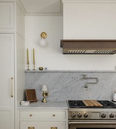 a stove top oven sitting inside of a kitchen next to a wall mounted oven hood