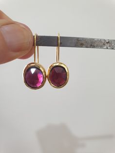 Garnet earrings, January birthstone earrings, drop gold Garnet earrings, red gemstone earrings, oval earrings, January birthday earrings These red, oval Garnet earrings were made in a simple, classic and chic design to create your go-to earrings for days and nights. These gold red gemstone earrings were 100% handmade and are a perfect gift for those celebrating their birthdays in January. Garnet is the official January birthstone and shines beautifully in the gold setting in a deep wine-red colo Ruby Earrings In Yellow Gold For Gift, Oval Fine Jewelry Earrings With Bezel Setting, Ruby Yellow Gold Earrings For Gift, Yellow Gold Ruby Earrings For Gift, Oval Birthstone Earrings For Formal Occasions, Gold Earrings With Ruby Birthstone, Gold Ruby Earrings With Birthstone, Oval Ruby Earrings For Anniversary, Yellow Gold Oval Earrings With Birthstone