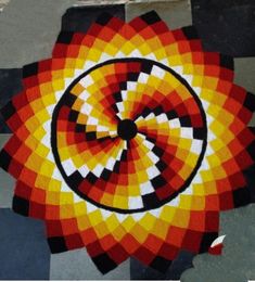 a circular design on the ground with black and white squares around it in red, yellow, and orange colors