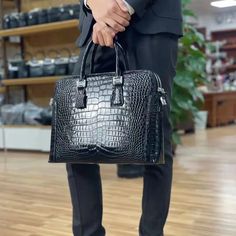 Amp up your trend with this essential crocodile-patterned briefcase. Crafted with genuine leather of the highest quality, it exudes luxury and sophistication. Designed as a solid pattern briefcase, it is perfect for men seeking style and functionality. The single strap ensures ease of carrying, making it ideal for business occasions. Elevate your style and make a statement with this must-have men's briefcase.