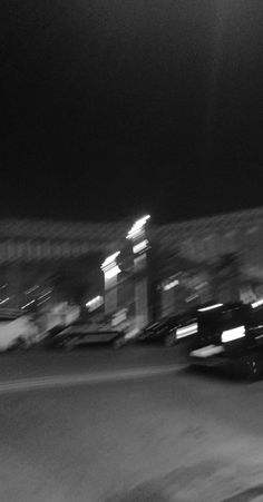 a black and white photo of a street at night