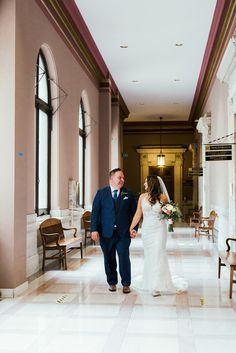 the bride and groom are walking down the hall