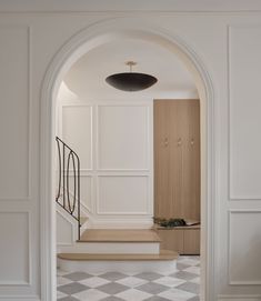 an open doorway leading to a hallway with white walls and checkered tile flooring