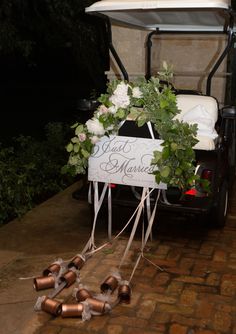 a golf cart decorated with flowers and ribbon tied to it's back for a wedding