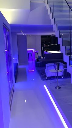 the interior of a modern house with purple lighting