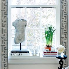 a window in a room with a white chair and vases on the windowsill