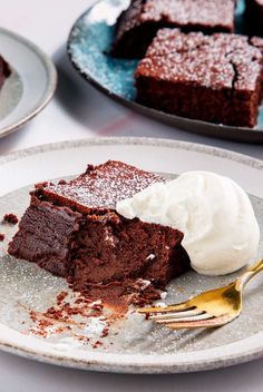 two plates with brownies and ice cream on them, one has a bite taken out of it