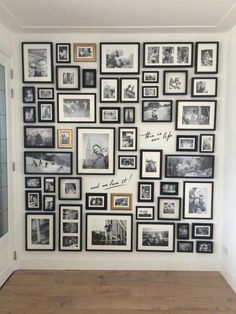 a wall with many pictures on it and some framed photos hanging up against the wall