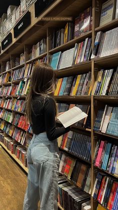 a woman standing in front of a bookshelf filled with lots of book's