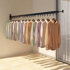 a rack with shirts hanging from it in front of a sliding glass door