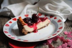 a piece of cheesecake on a plate with cherries