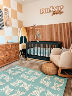 a baby's room with a crib, rocking chair and surfboard on the wall