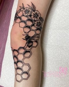 a tattoo on the arm of a woman with flowers and honeycombs in it