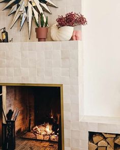 a fire place in a living room with a clock on the wall above it and other decorations