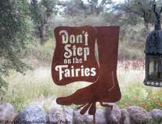 a sign that says don't step on the fairiess with a lamp hanging from it