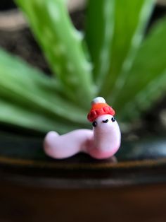 a small toy snail sitting on top of a plant