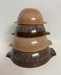 three brown and white bowls stacked on top of each other