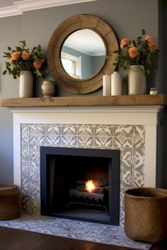 a fireplace with a mirror above it and flowers on the mantle