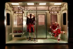 two mannequins dressed in red and white are sitting on the subway car